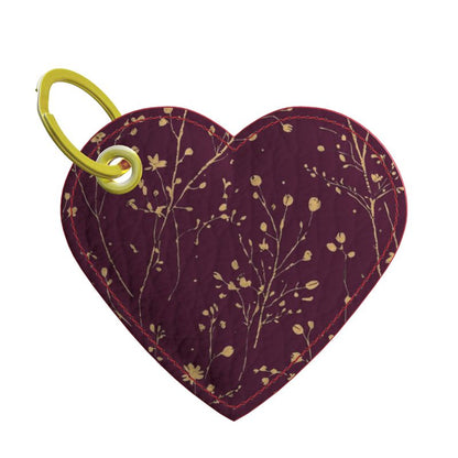 Heart-shaped pouch with floral pattern and green clip on a white background