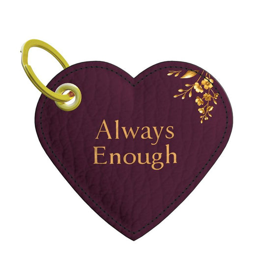 Wine-colored heart-shaped Nappa leather keychain with painted edges, gold floral detail, and gold foil affirmation “Always Enough”