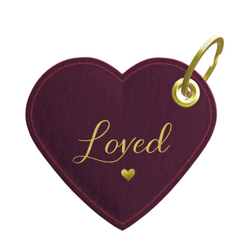 Heart-shaped keychain with 'Loved' text and gold accents on a white background