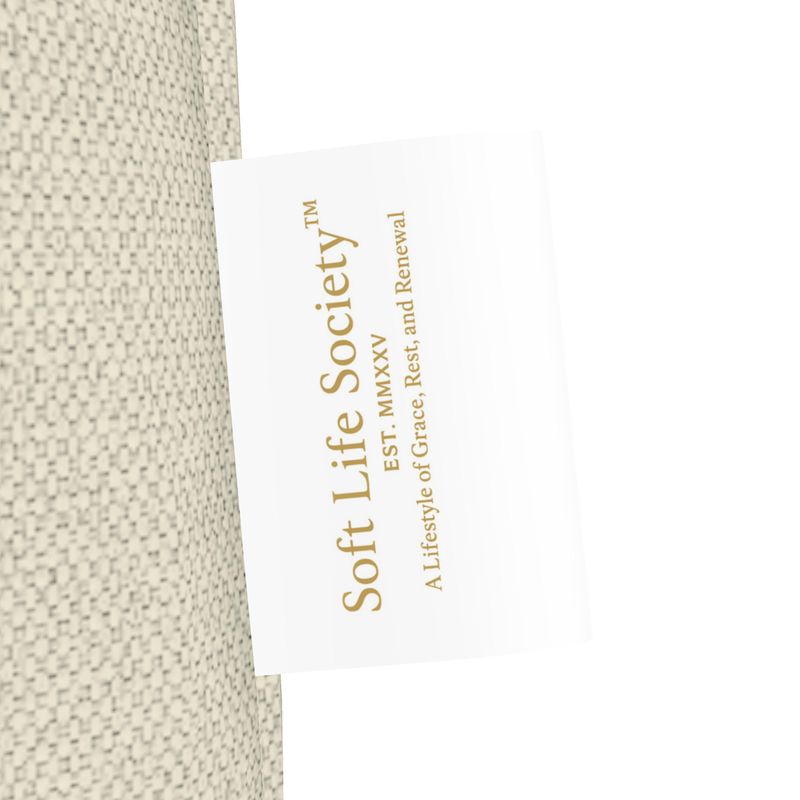 Side view of beige tote bag with 'Soft Life Society' label on a white background