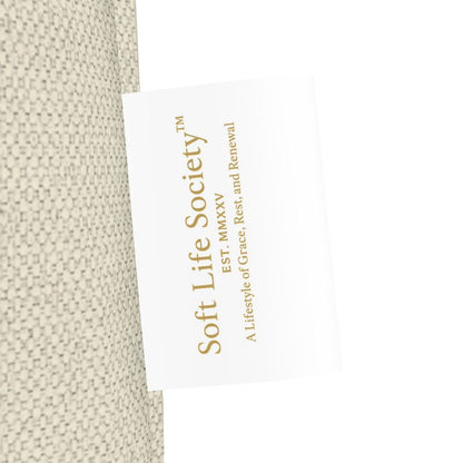 Side view of beige tote bag with 'Soft Life Society' label on a white background