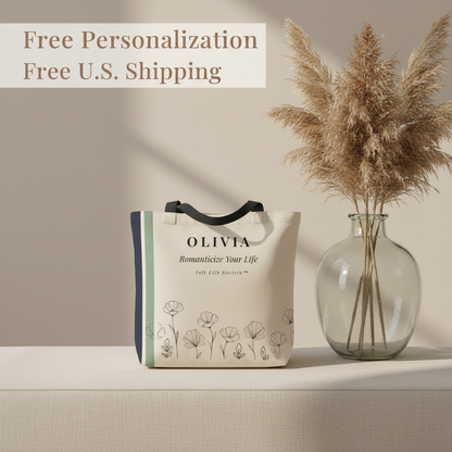 Tote bag with 'OLIVIA' branding next to a vase with dried plants on a neutral background.