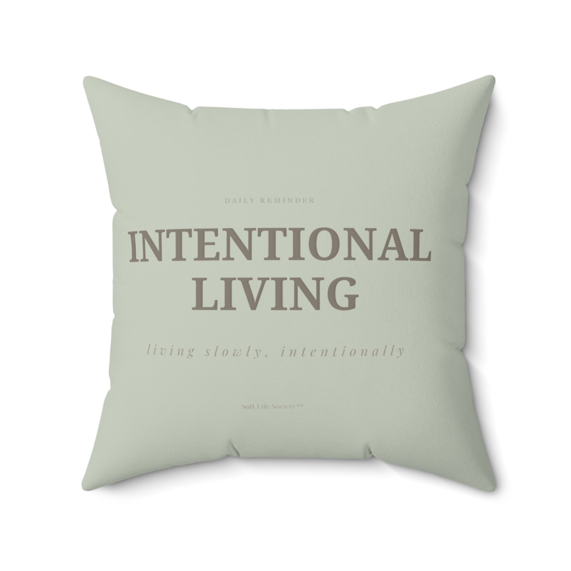 Light green pillow with 'Intentional Living' text on a white background