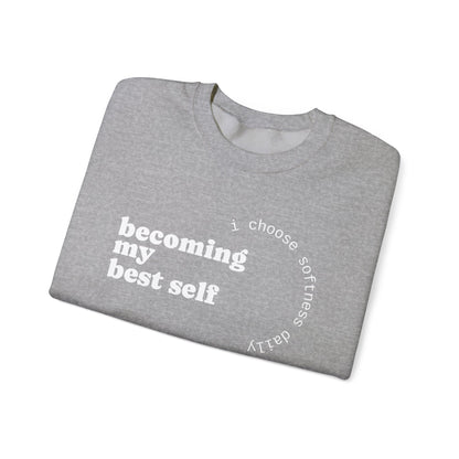 Heather grey sweatshirt displayed flat with “becoming my best self” circular softness quote design.