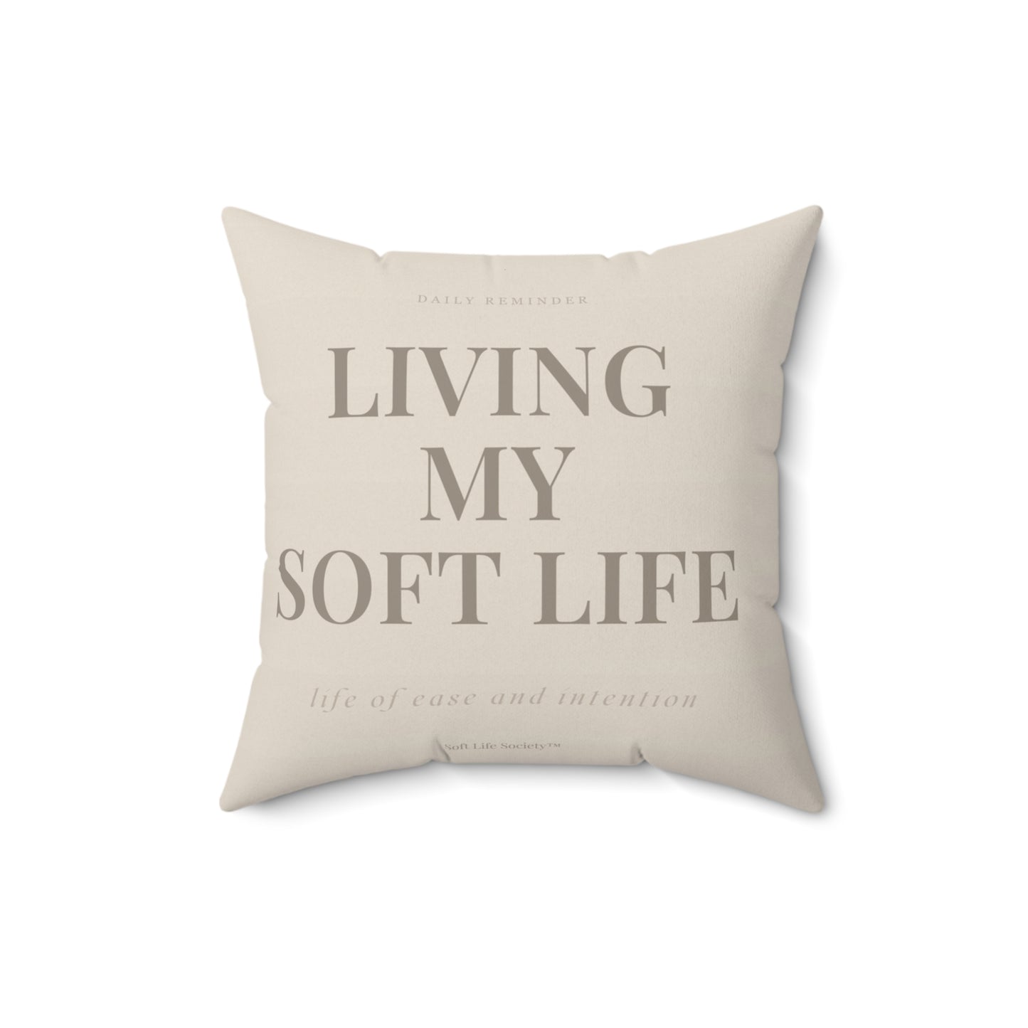 Beige pillow with text 'Living My Soft Life' on a white background