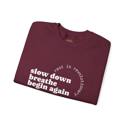 Folded maroon sweatshirt with motivational text on a white background