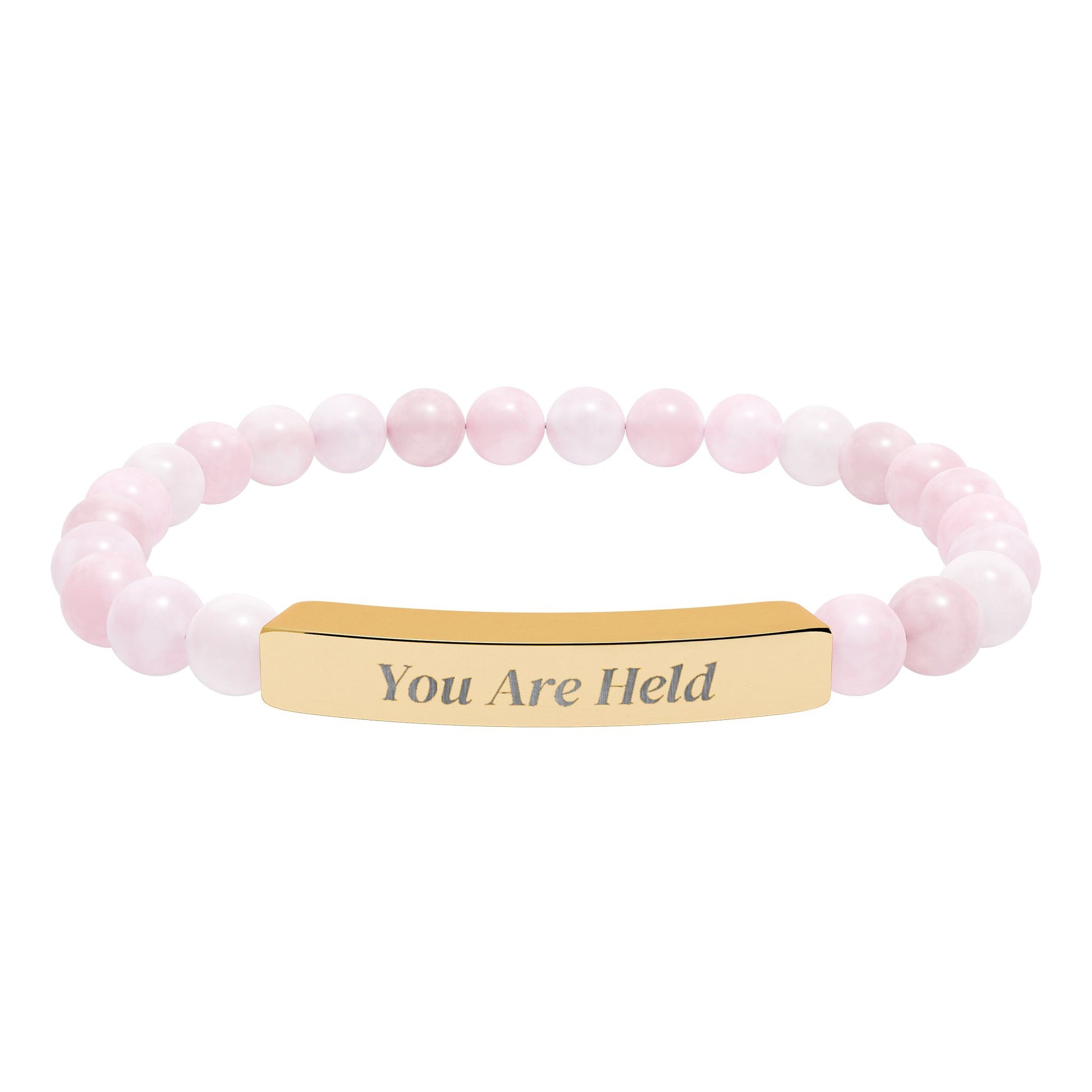 Rose quartz beaded stretch bracelet with engraved 18K gold bar reading “You Are Held,” shown on a white background.