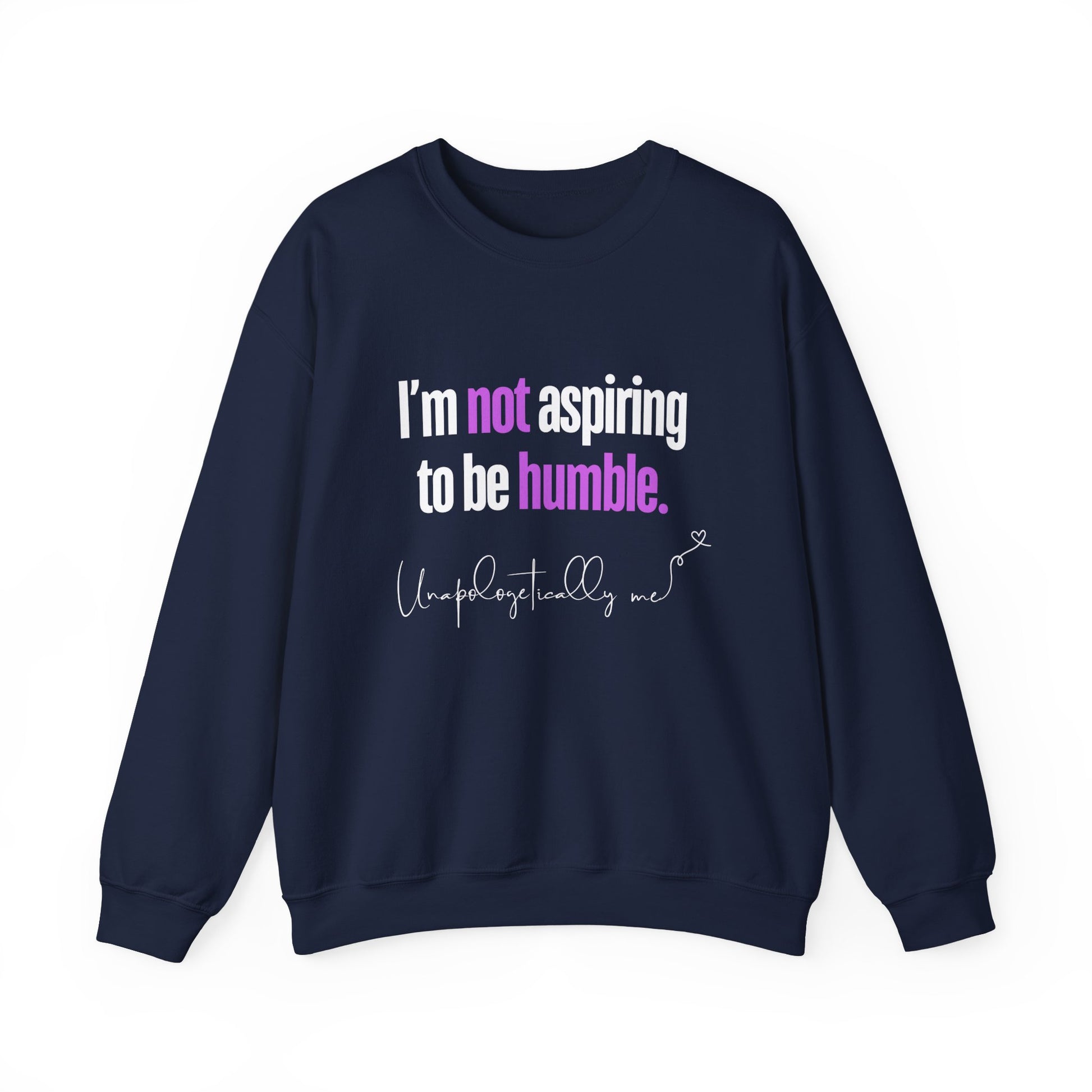 A navy blue sweatshirt featuring the quote "I'm Not Aspiring To Be Humble" in bold white and purple text, with "Unapologetically Me" script at the bottom.