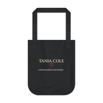 Back view of the Tokyo After Midnight black organic cotton tote featuring Tania Cole branding and collection website.
