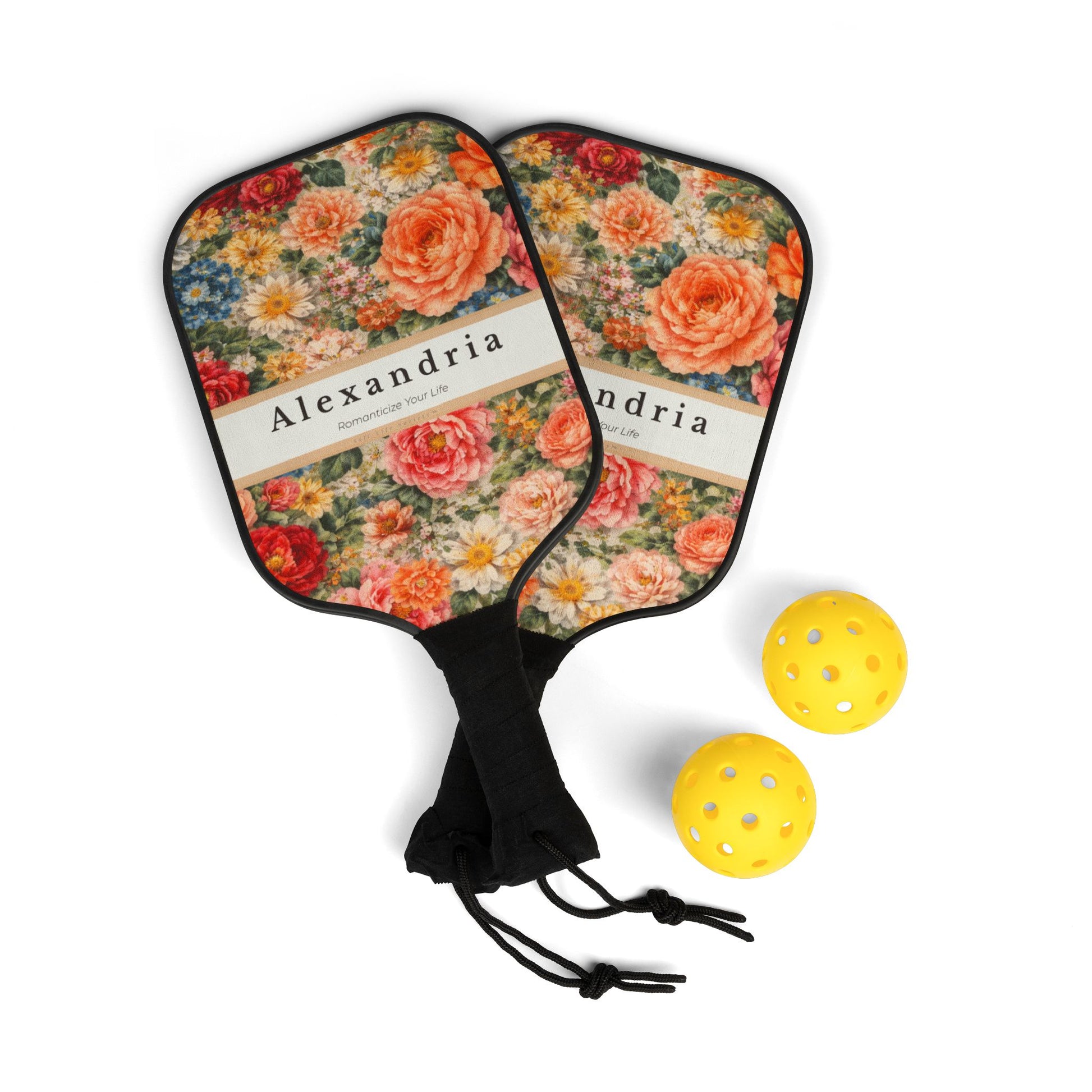 Floral-patterned pickleball paddles with 'Alexandria' branding and two yellow pickleballs on a white background.
