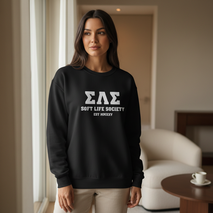 Woman wearing a black sweatshirt with 'ΣΛΣ SOFT LIFE SOCIETY EST 1920' text in a room.