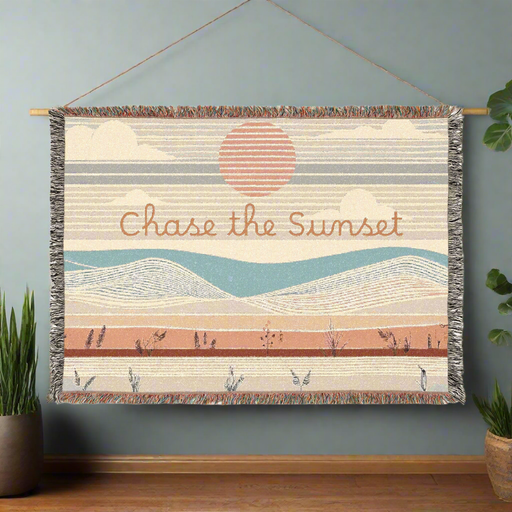 "Chase the Sunset" woven blanket displayed as a wall tapestry, adding Southwestern charm to the room.