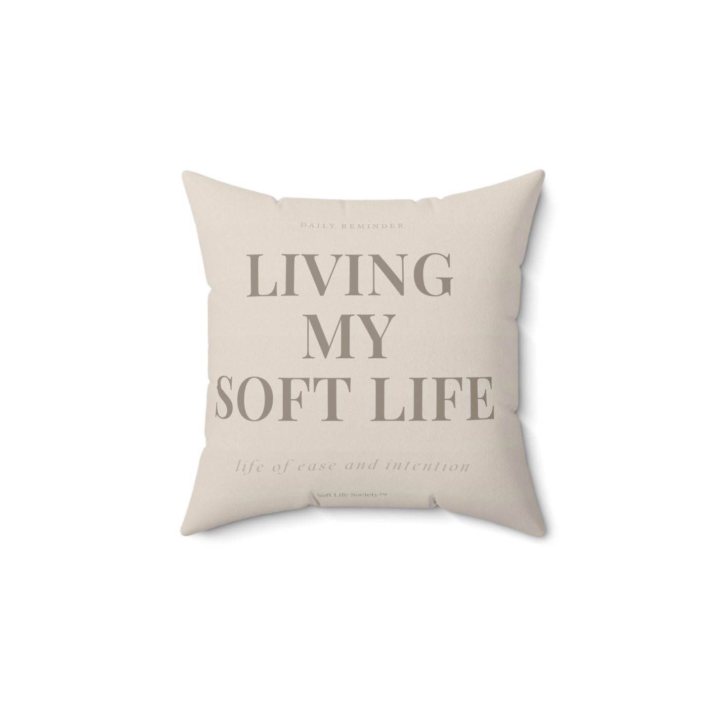 Beige pillow with text 'Living My Soft Life' on a white background