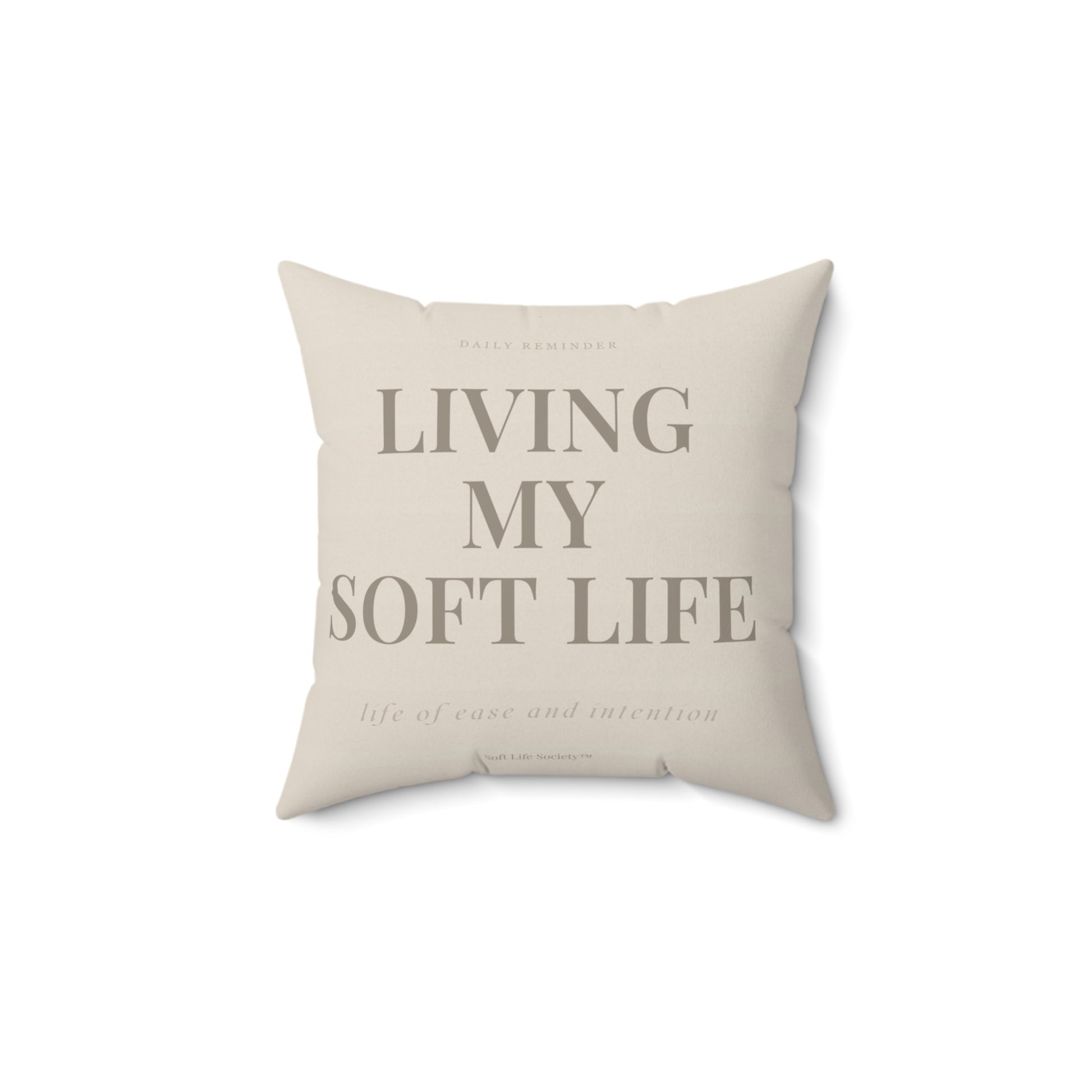 Beige pillow with text 'Living My Soft Life' on a white background