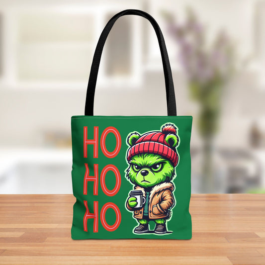 Green tote bag featuring a grumpy, Grinch-inspired teddy bear wearing a red beanie and jacket, alongside bold 'HO HO OH' lettering, perfect for holiday shopping.