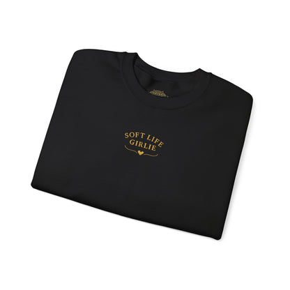 Folded black sweatshirt with 'Soft Life Girlie' text on a white background