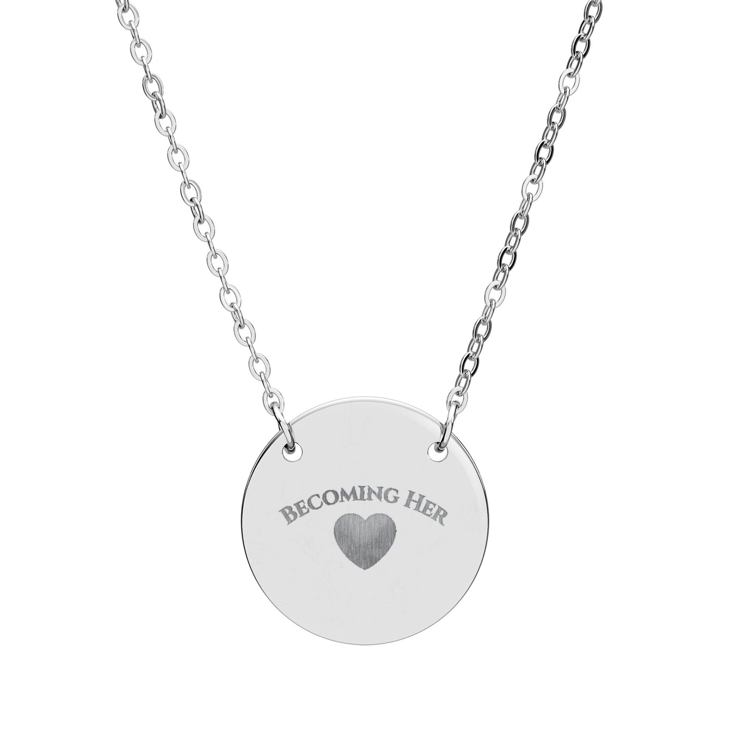 Silver necklace with a round pendant engraved with 'Becoming Her' and a heart symbol on a white background.