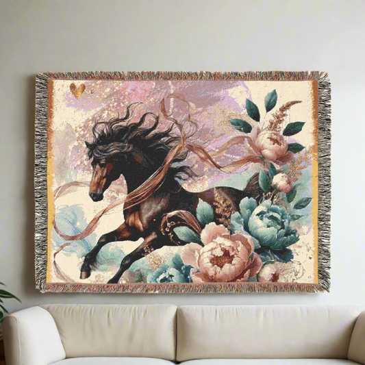 A stunning woven blanket featuring a galloping black horse with vibrant florals, mounted elegantly on a neutral-colored wall above a minimalist sofa.