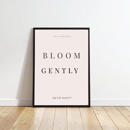 Framed print with 'Bloom Gently' text on a white wall.