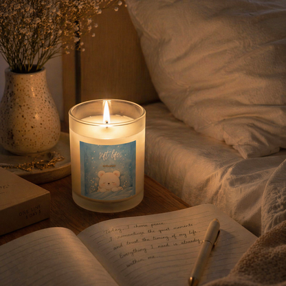 Soft Life candle glowing beside open book in cozy bedroom, evening self care scene