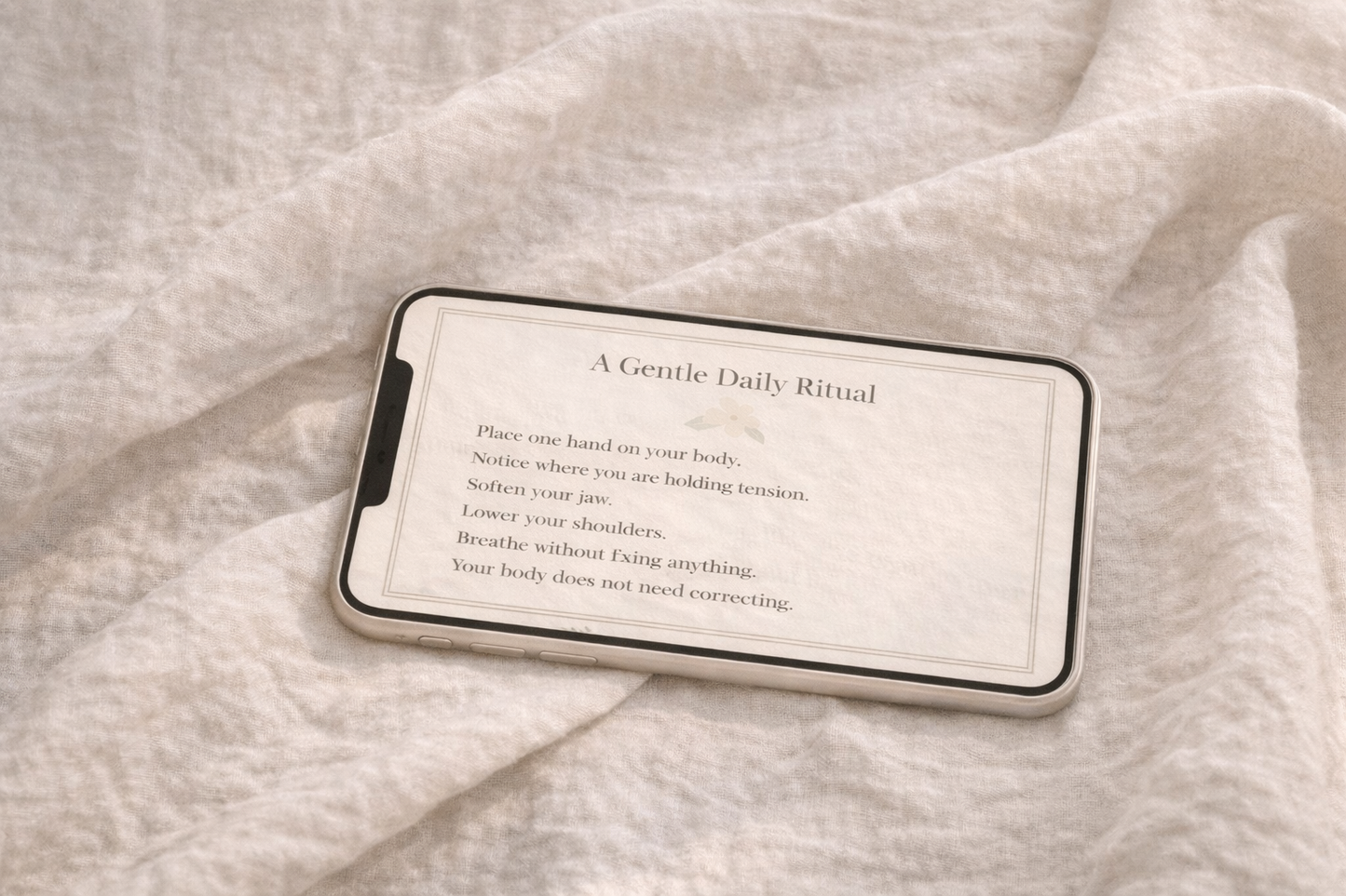 Smartphone displaying a digital ritual card in landscape orientation, resting on textured linen fabric with a calm, minimalist aesthetic.