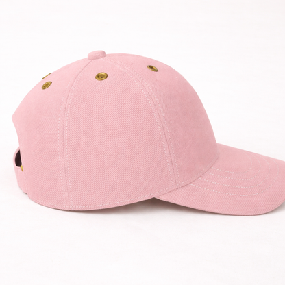 Angled side view of blush pink baseball cap highlighting soft fabric texture and stitching