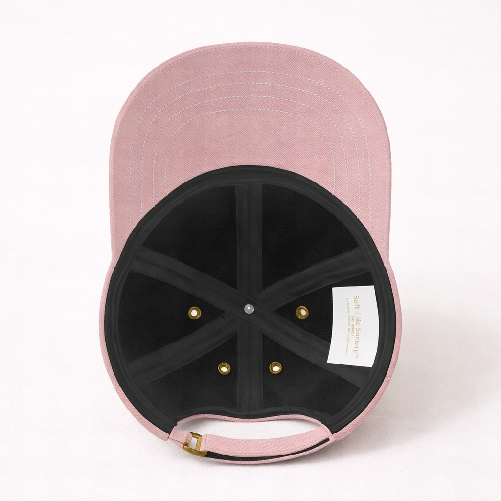 Interior view of pink baseball cap with a brand label on a white background