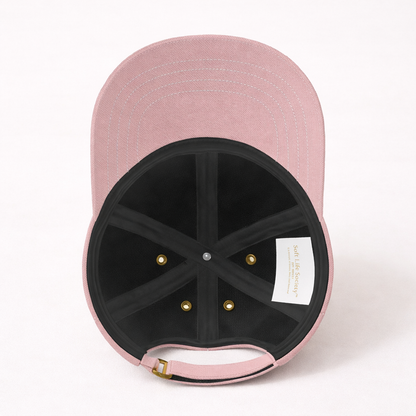 Interior view of pink baseball cap with a brand label on a white background