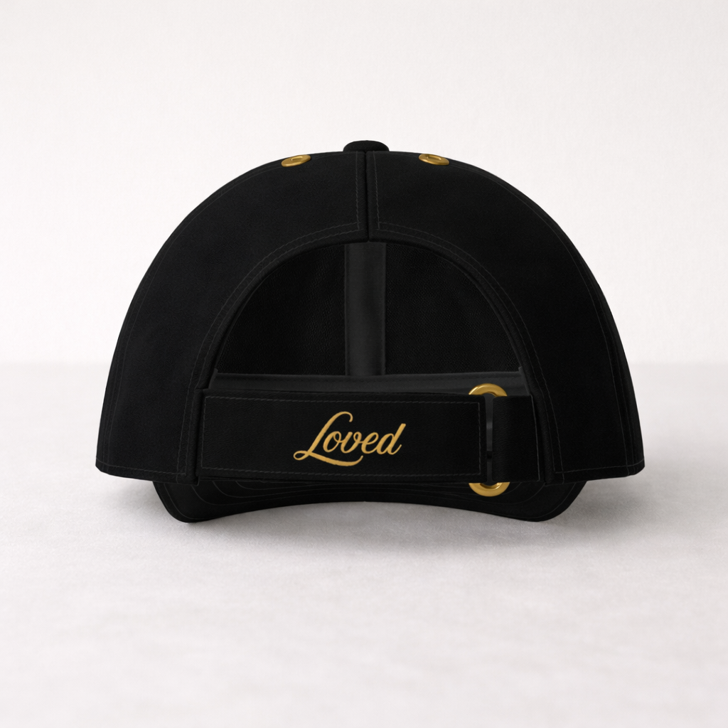 Black cap with 'Loved' text in gold on a white background