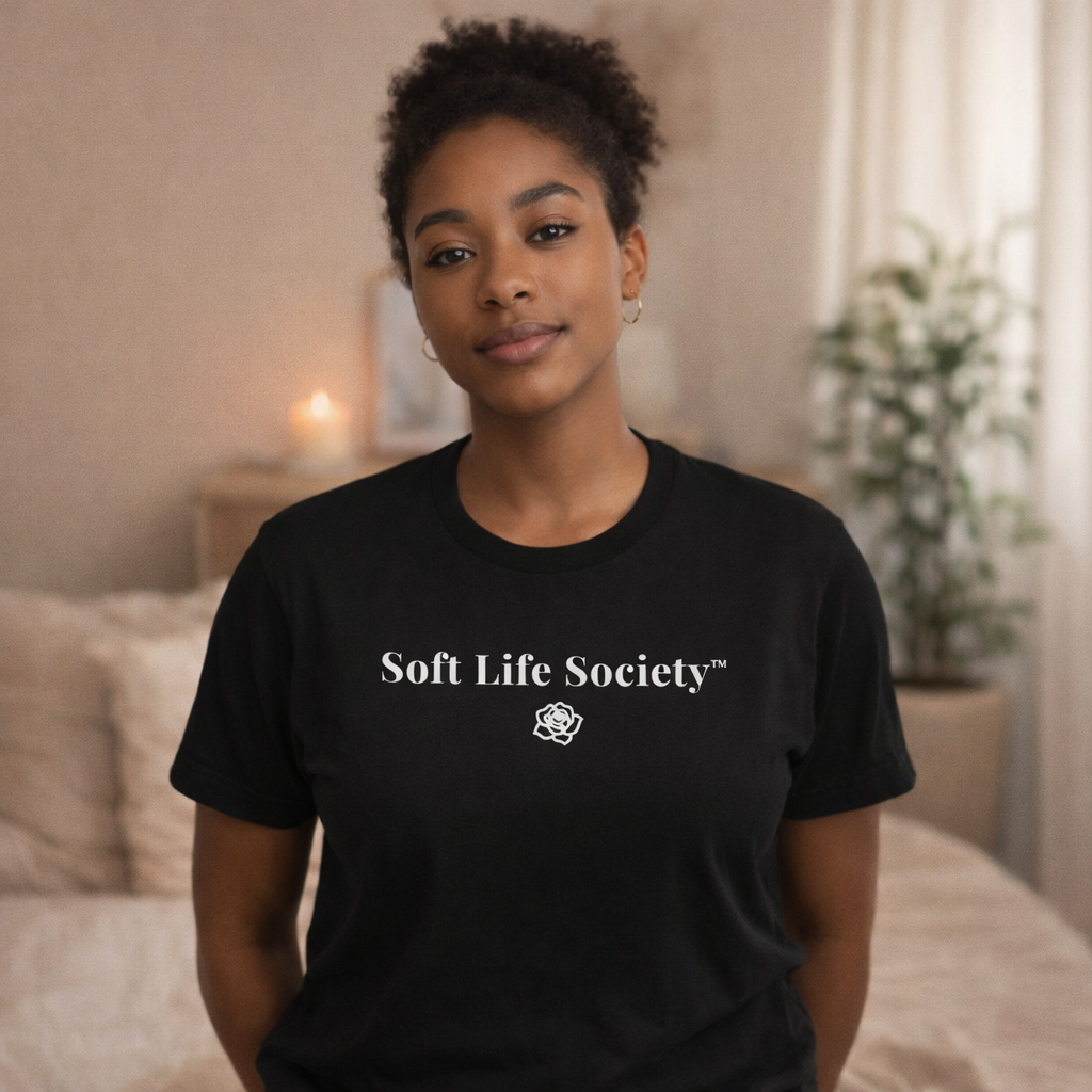 Woman wearing black Soft Life Society t-shirt with relaxed fit, styled casually with denim in soft neutral setting