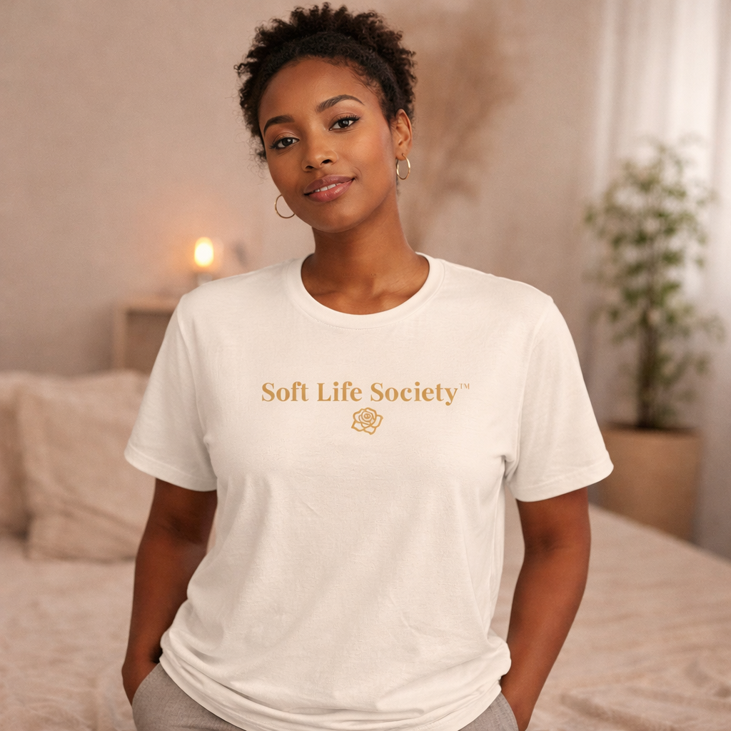 Woman wearing cream Soft Life Society t-shirt with gold logo, relaxed soft life aesthetic outfit