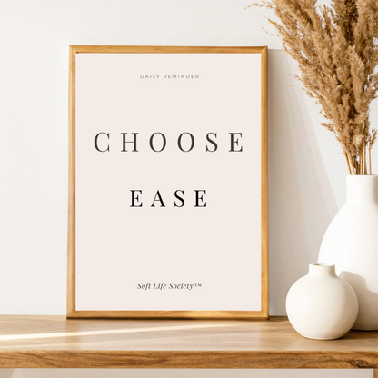 Framed print with 'CHOOSE EASE' text on a wooden shelf with decorative vases.