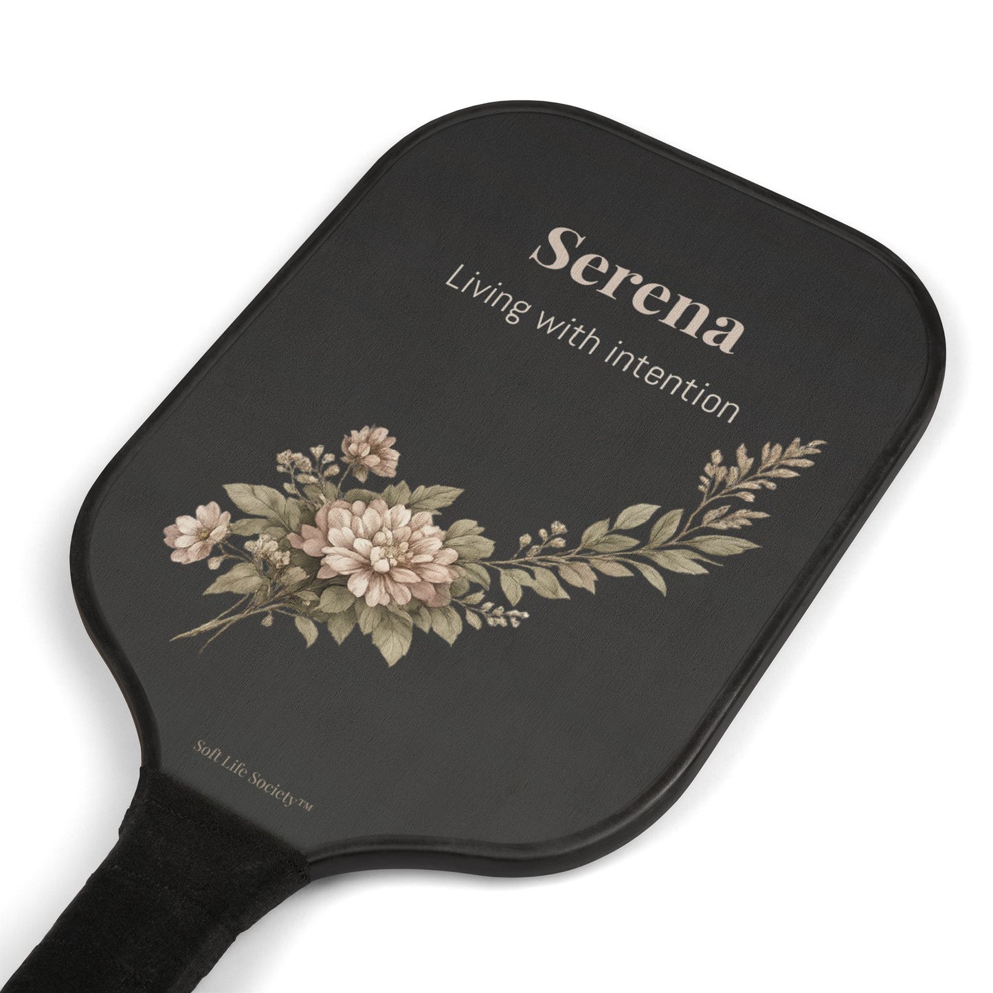 Black paddle with floral design and 'Serena' branding on a white background