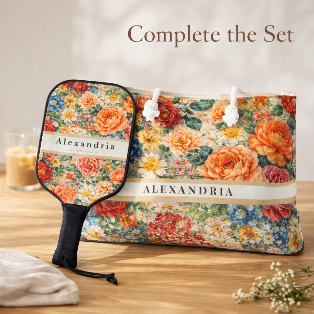 Floral-patterned paddle and matching weekender bag set with 'Alexandria' branding on a wooden surface.