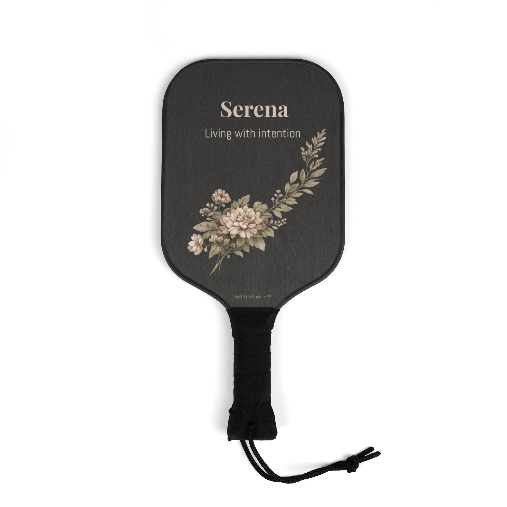 Black paddle with floral design and 'Serena' branding on a white background