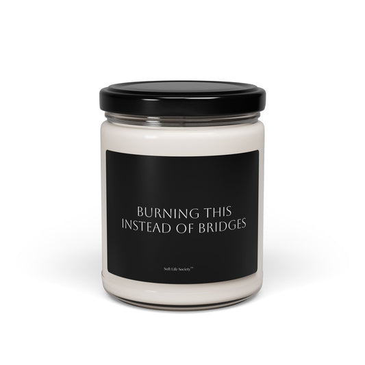 Candle jar with a black label with 'Burning this instead of Bridges' on a white background
