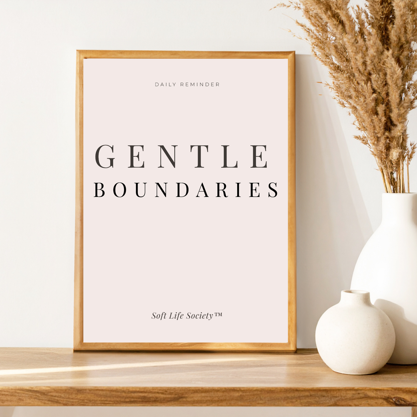 Framed print with 'Gentle Boundaries' text on a wooden shelf with decorative vases.
