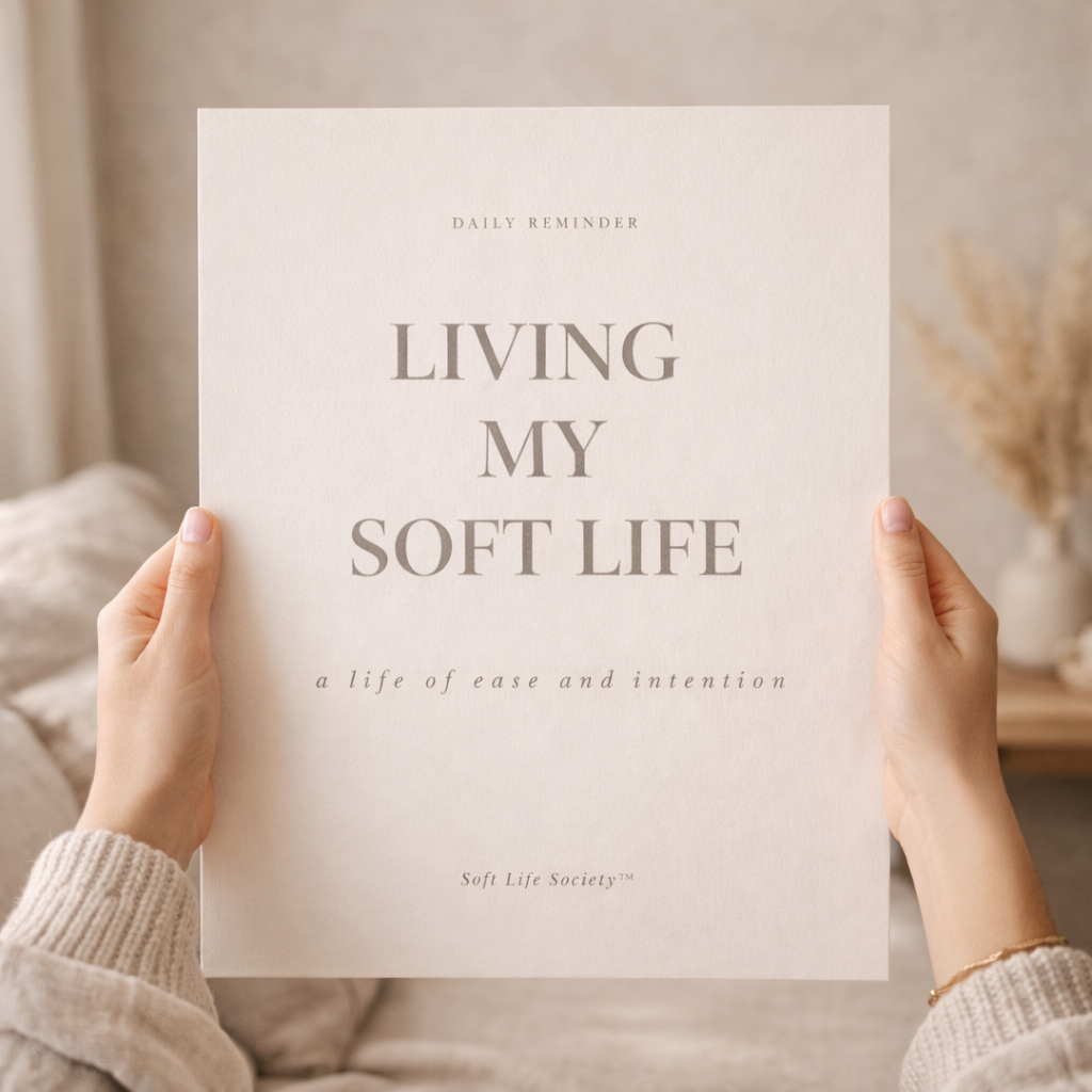 Person holding a sign with 'Living My Soft Life' text in a cozy indoor setting.