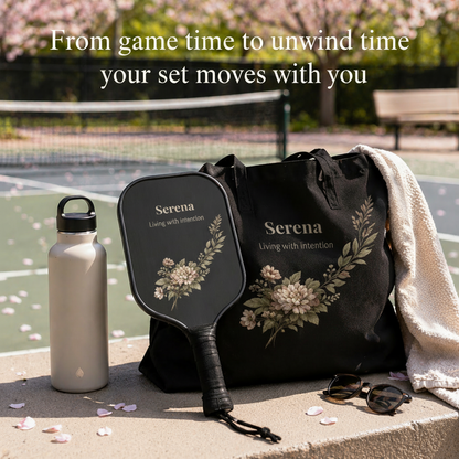 Black bag, paddle, water bottle, and towel on a ledge with cherry blossoms in the background