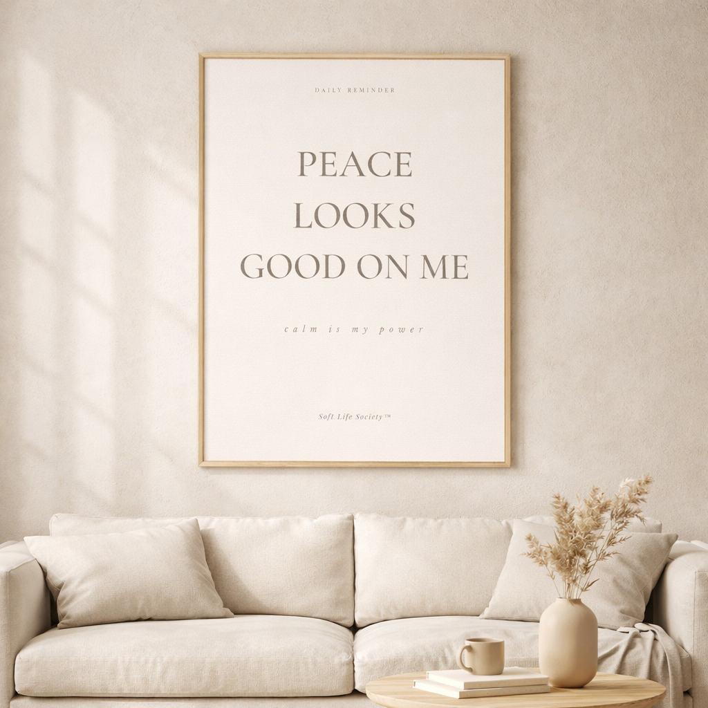 Framed artwork with 'Peace Looks Good on Me' text above a beige sofa in a living room.