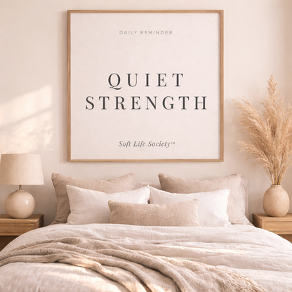 Bedroom with a framed print on the wall displaying 'Quiet Strength' by Soft Life Society.