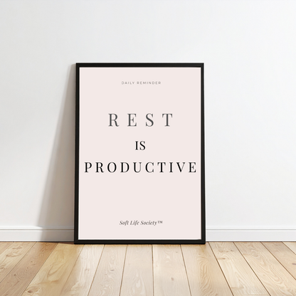 Framed poster with 'REST IS PRODUCTIVE' text on a white wall.
