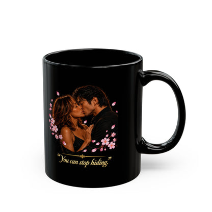 A black ceramic mug featuring a printed graphic featuring Simone and Ren-inspired romantic artwork surrounded by pink cherry blossoms, with the gold text 'You can stop hiding' below them, set against a plain white background.