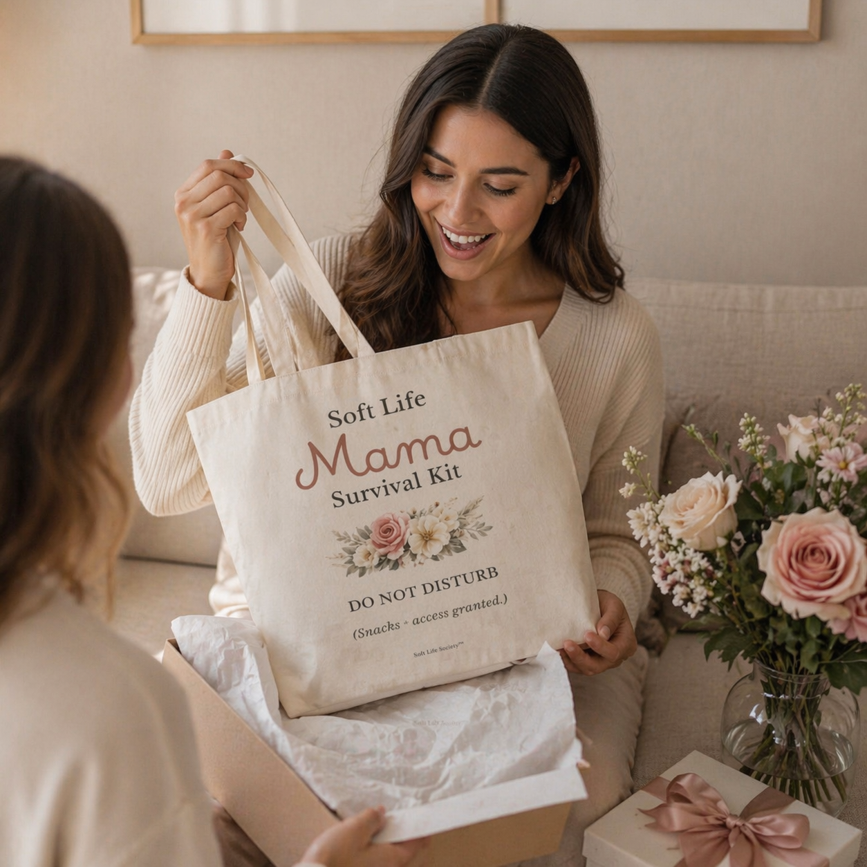 Woman receiving a 'Soft Life Mama Survival Kit' bag as a gift.