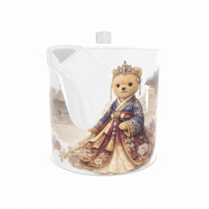 Teapot with a teddy bear in a royal costume on a white background