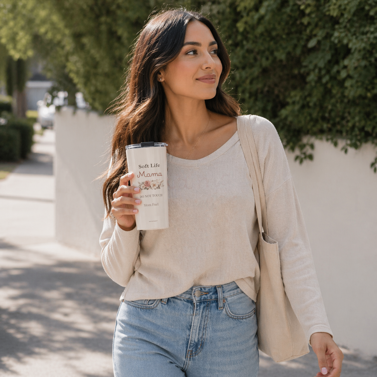 Woman walking outdoors holding Soft Life Mama tumbler and tote bag, everyday mom lifestyle with neutral outfit and aesthetic drinkware