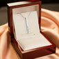Silver engraved bar necklace in luxury red jewelry box on satin backdrop