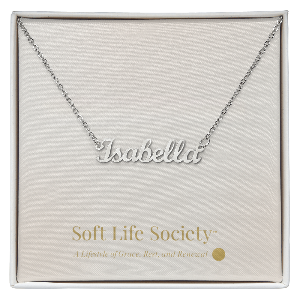Silver custom name necklace reading ‘Isabella’ displayed on a Soft Life Society™ white message card.