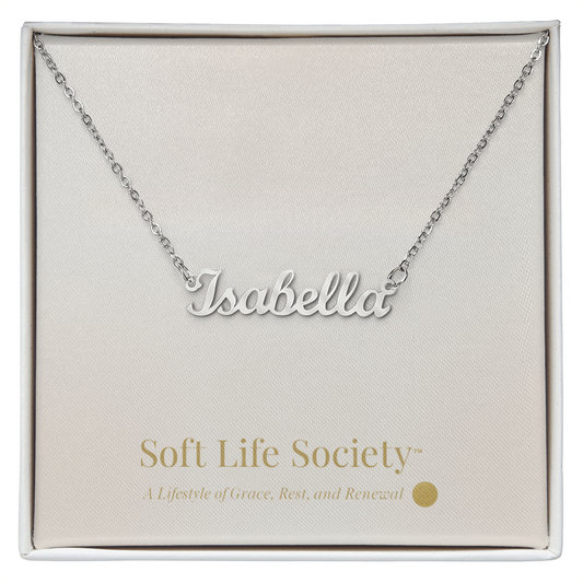 Silver custom name necklace reading ‘Isabella’ displayed on a Soft Life Society™ white message card.