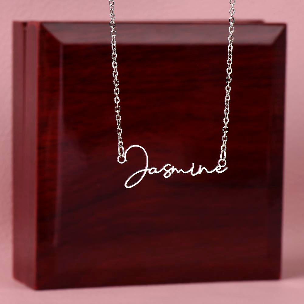 Soft Life Society Signature Style Name Necklace in silver with “Jasmine” script pendant displayed in front of a mahogany luxury jewelry box on a blush pink background.
